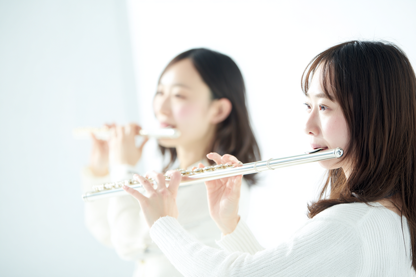 フルートを吹く初心者の女性2人