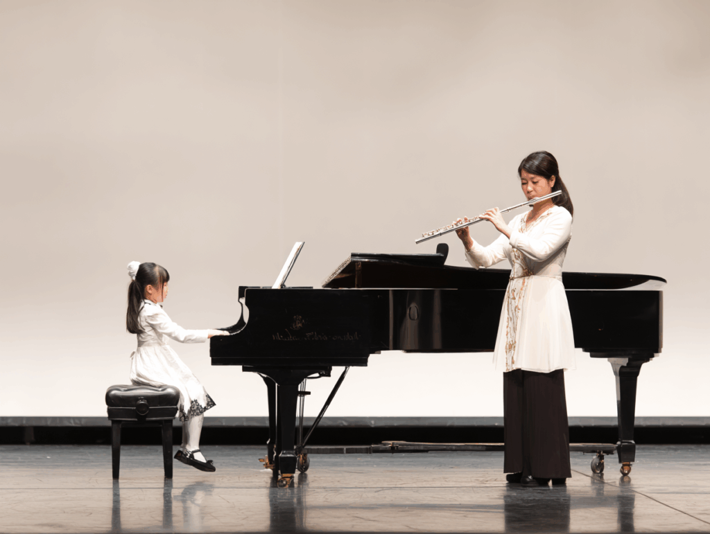 演奏会でフルートを吹く親子